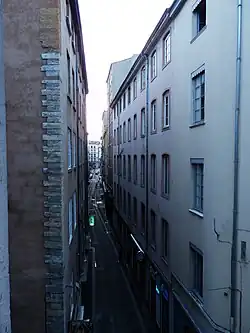 L’extrémité est de la rue, le soir.