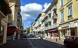 Vue en couleurs d'une rue commerçante et centrale d'une ville.