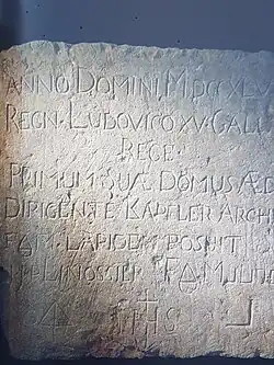 Pierre sculptée avec texte en latin.