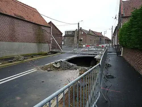 Effondrement de la chaussée causé par la présence de vides dans le sous-sol consécutifs à l'exploitation de la pierre calcaire.