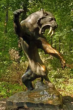 Statue reconstituant un tigre à dents de sabre dans un parc.