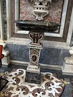 L'un des bénitiers dans l'église, tout en différents marbres polychromes.