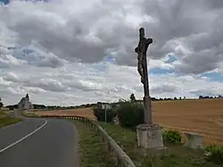 Le calvaire sur la D 61 avec l'église au fond.