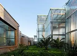 Photographie de la verdure du Jardin Botanique entouré de bâtiments en verre modernes.