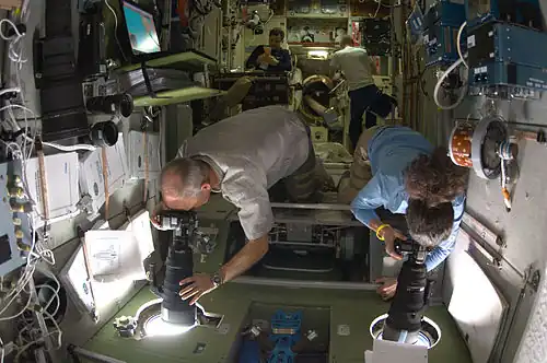 Prise de photos par les hublots de la station dans la partie la plus étroite du module.