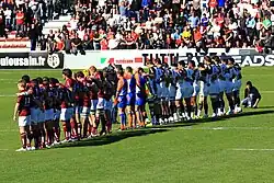 Deux équipes alignées de part et d'autre des arbitres