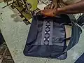 Fabrication de sac pour ordinateur en cuir et pagne tissé au village artisanal de Soumbedioune