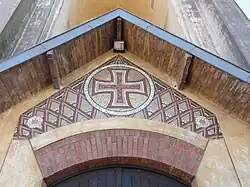 Détail de la croix pattée au-dessus du portail