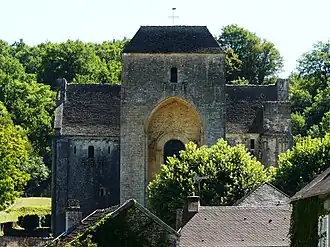 Au-dessus des toits du village, la masse imposante de l'église abbatiale.