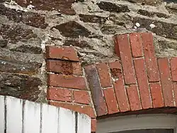Impacts de balles sur un bâtiment du bourg ayant survécu.