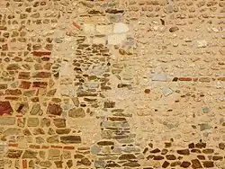 Fenêtre romane murée dans le mur de l'église.