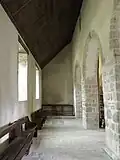 Le collatéral nord, couvert en appentis, et son autel oriental.