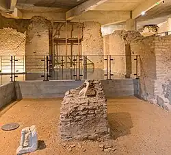 Vue d'une partie du sous-sol du musée, construit en conservant les murs d'anciennes constructions romaines, avec un autel domestique au centre