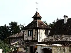 Maison à colombages surmontée d'un pigeonnier décoratif.