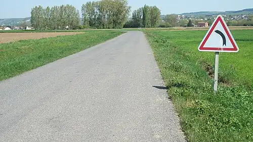 Route avec panneau annonçant un virage à gauche