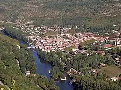Le village est longé par une rivière et entouré par la végétation.