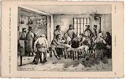 Dans une pièce miséreuse évoquant un tripot des hommes sont pour les uns attablés, d'autres devisent.