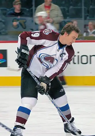 Photo de Joe Sakic avec le numéro 19 et le C de capitaine de l'Avalanche du Colorado.