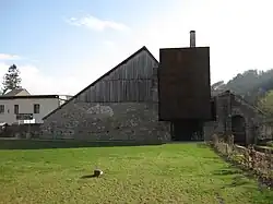 Photographie en couleurs d'un bâtiment entouré de pelouse.