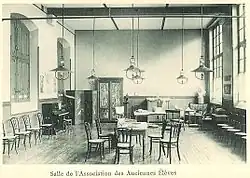 Photographie de la salle de l'AAE à la fin du XIXe&nbsp;siècle : il y a des meubles, un piano et un buste de Molière.