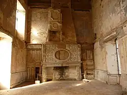 La salle d'apparat du Château Jeune, avec une cheminée en bois sculpté avant sa restauration en 2013.