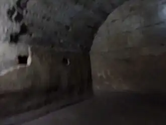 Pièce intérieure. Mur enduit en opus signinum et trous de charpente.