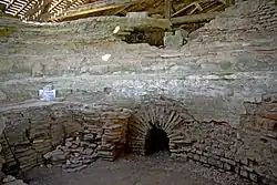 Vue de murs antiques avec une ouverture voûtée en plein cintre.