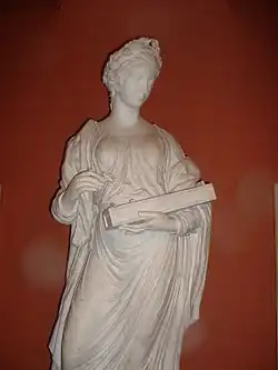 Statue grecque en pied d'une femme couronnée de lauriers, tunique drapée, un instrument en main (environ 50&nbsp;cm).