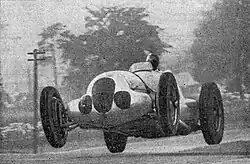 Photo d'une voiture lancée à pleine vitesse et décollant des quatre roues.