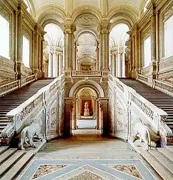 Photo d'un grand double escalier à l’intérieur d'un palais richement décorée.