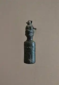 Sceau-cylindre en bronze, surmonté de la tête du démon Pazuzu. VIIe&nbsp;siècle&nbsp;av. J.-C. Musée du Louvre.