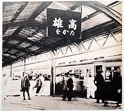 Photographie en noir et blanc d'un quai de gare en Asie.