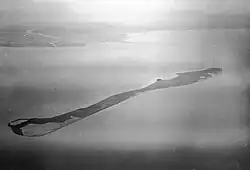 Photographie en noir et blanc et en altitude d'une étendue d'eau entourant une île