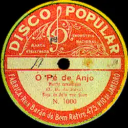 Photographie en couleur du centre d'un disque 78 tours. Le centre est représenté par un disque principalement orange avec un pourtour jaune. Il y est notamment écrit le titre de la chanson et le nom du label discographique, Disco Popular.