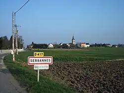 Entrée par la route départementale 417 et le centre du village au second plan