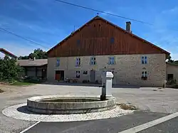 Abreuvoir rond devant ferme comtoise.