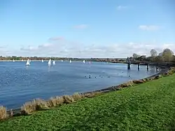 Photo d'un plan d'eau sur lequel voguent plusieurs petits bateaux à voile