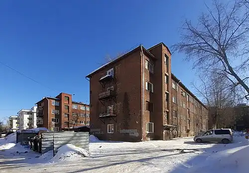 Photographie couleur d'une rangée de barres d'immeubles sous la neige.