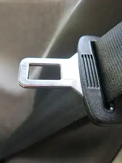 Gros plan sur une boucle métallique d'une ceinture de sécurité, le long de la sangle
