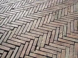 Le sol de la place en briques posées en épi.