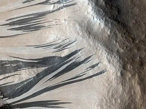 Traînées noires photographiées le 3 décembre 2006 par l'instrument HiRISE de MRO dans la région d'Acheron Fossae.