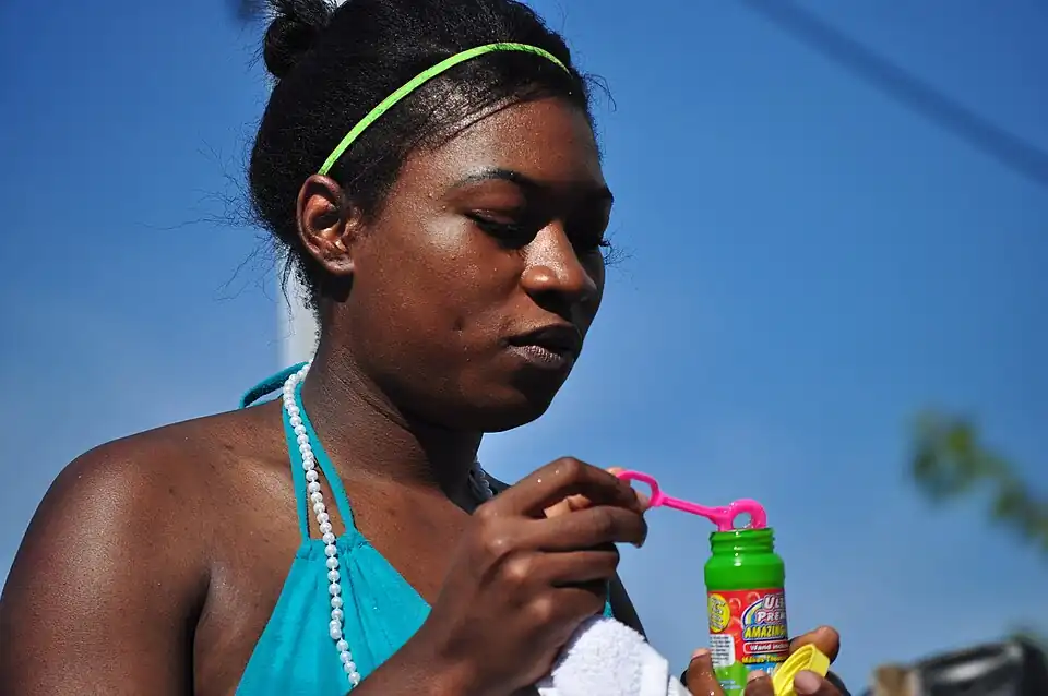 Une femme sortant d'un tube à bulles une baguette à bulles (Fremont Solstice Parade&nbsp;(en), États-Unis).
