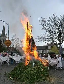 Le mannequin en paille brûle sur un bûcher, autour duquel des Soufflaculs dansent en formant un cercle.