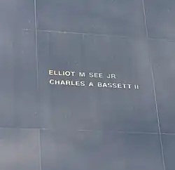 Photographie en couleur de noms gravés en doré sur un monument noir.