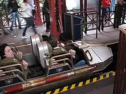 Wagon cuivré avec trois personnes embarquées.