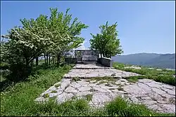 Vue d'un paysage, au centre une maison en pierre