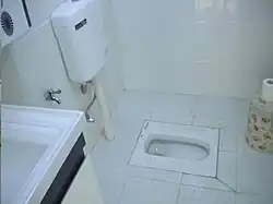 WC à la turque en porcelaine, avec réservoir d'eau pour le rinçage (Wuhan, Chine)