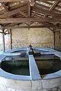 Le lavoir doté de quatre bassins. Chaque bassin a un bac pour le lavage et un bac pour le rinçage.