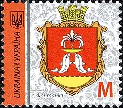 Photographie couleur. Timbre postal édité en 2020 arborant les armoiries de Fontanka. Sur le côté gauche, sur un axe vertical, « Ukraina » et « Україна » sont inscrits en caractères noirs sur un bandeau orange, surmontées des armoiries de l’Ukraine.
