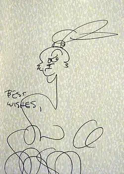 dessin rapide au crayon noir d'un seul trait où l'on devine la tête du lapin. Le dessin est accompagné d'u la mention en anglais "best wishes" et de la signature de l'auteur.
